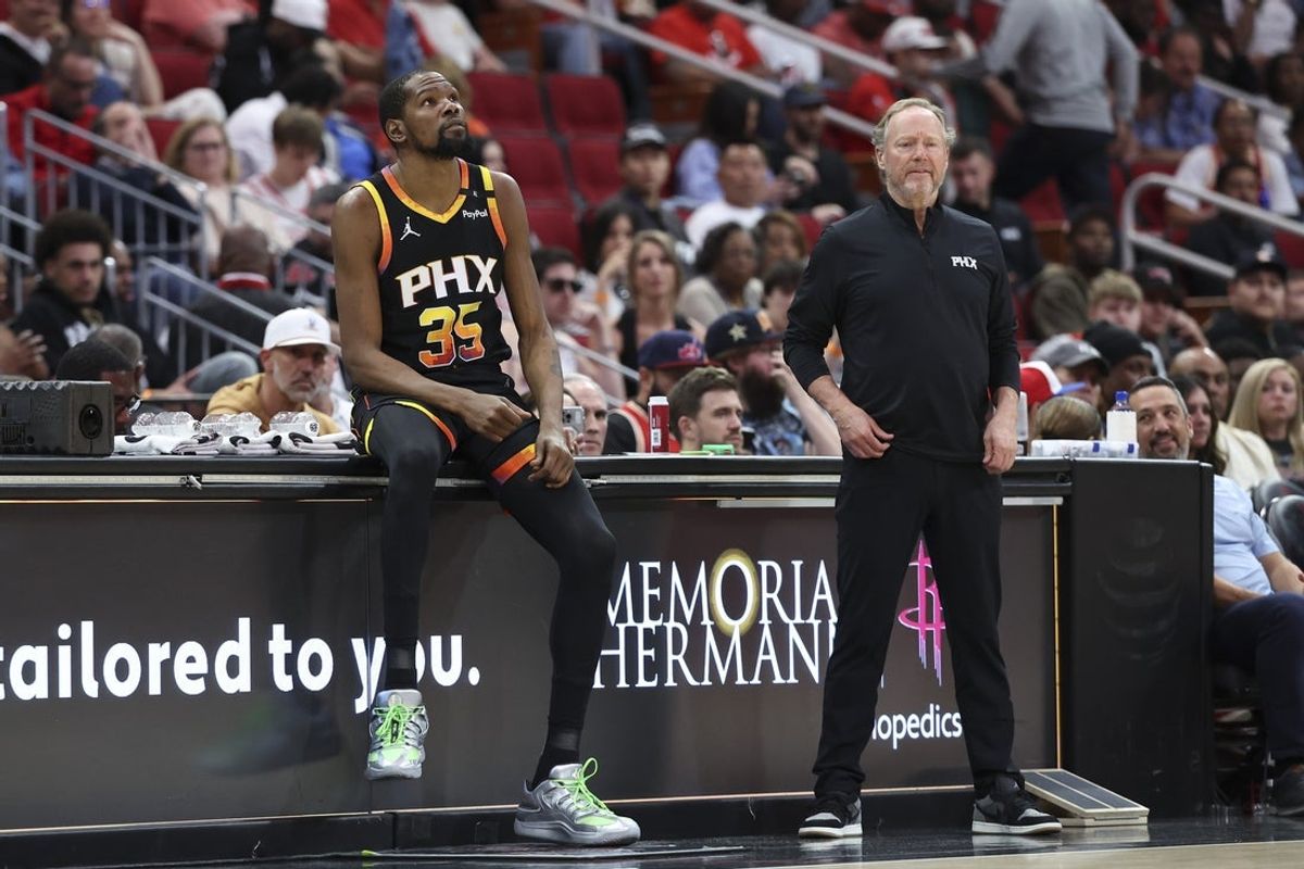 Mar 12, 2025; Houston, Texas, USA; Phoenix Suns forward Kevin Durant (35) sits on the scorers table as head coach Mike Budenholzer looks on during the second quarter against the Houston Rockets at Toyota Center. Mandatory Credit: Troy Taormina-Imagn Images