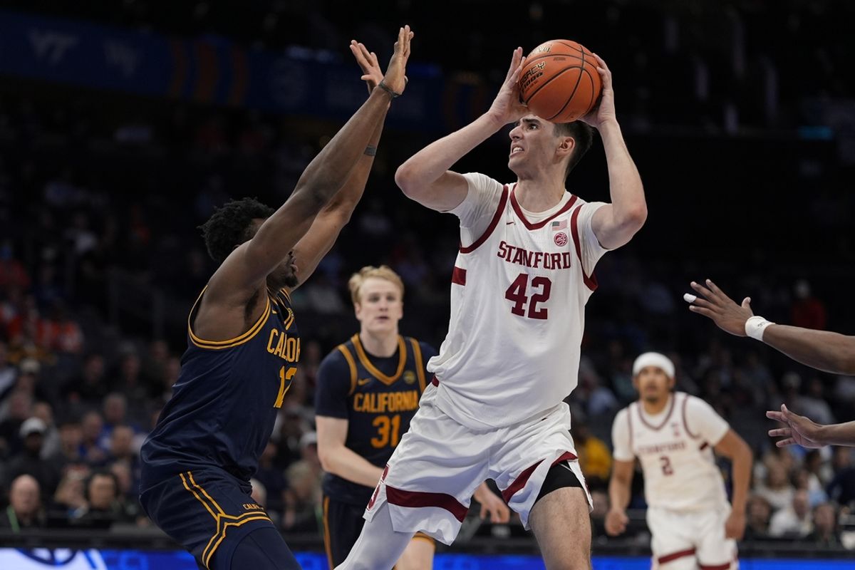 Mar 12, 2025; Charlotte, NC, USA; Stanford Cardinal forward Maxime Raynaud (42) turns to shoot defended by California Golden Bears center Mady Sissoko (12) during the second half at Spectrum Center. Mandatory Credit: Jim Dedmon-Imagn Images