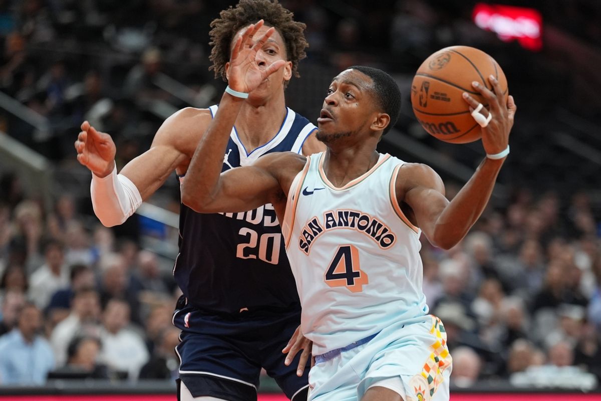 Mar 12, 2025; San Antonio, Texas, USA; Dallas Mavericks forward Kessler Edwards (20) defends against San Antonio Spurs guard De'Aaron Fox (4) in the first half at Frost Bank Center. Mandatory Credit: Daniel Dunn-Imagn Images