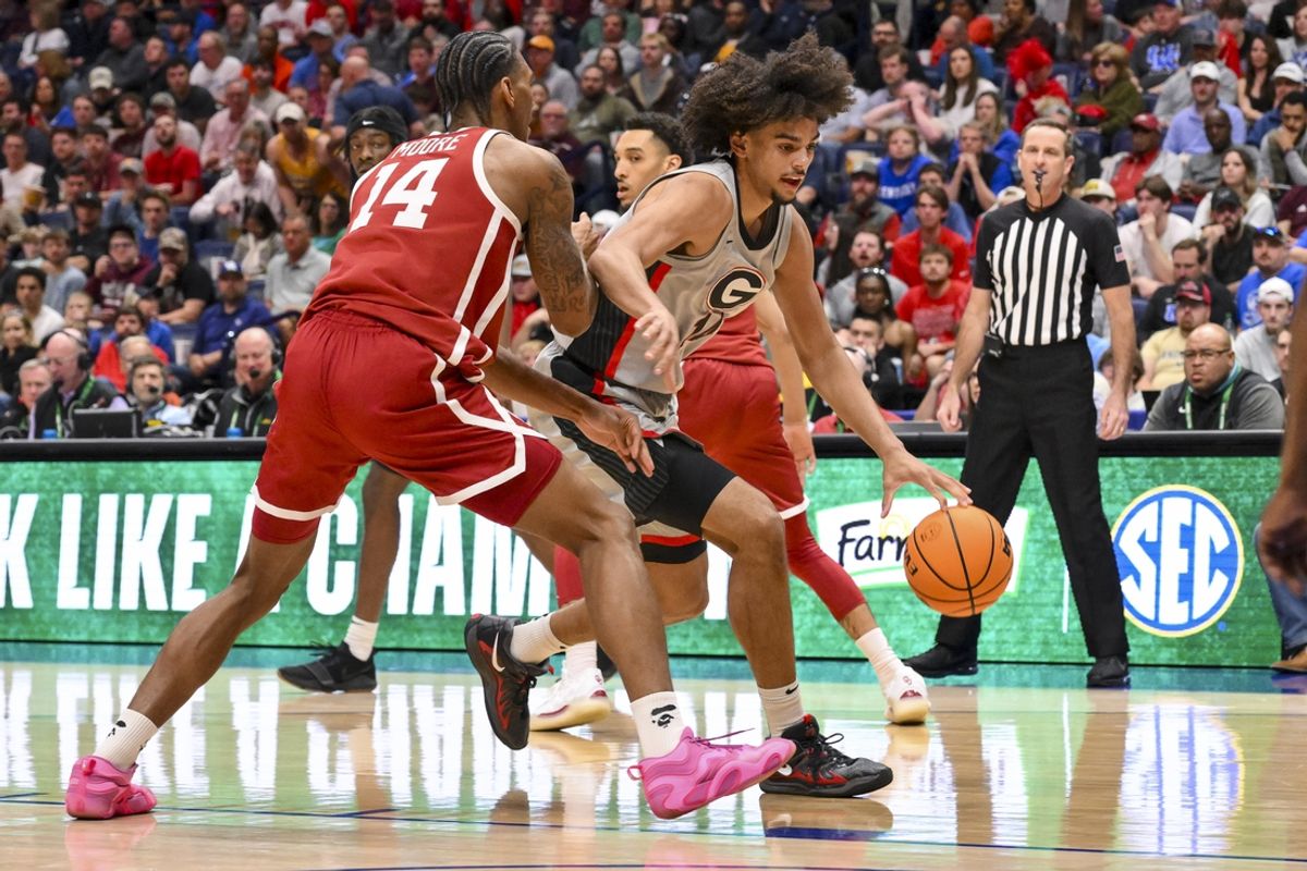 Mar 12, 2025; Nashville, TN, USA;  Georgia Bulldogs forward Asa Newell (14) dribbles past Oklahoma Sooners forward Jalon Moore (14) during the first half at Bridgestone Arena. Mandatory Credit: Steve Roberts-Imagn Images