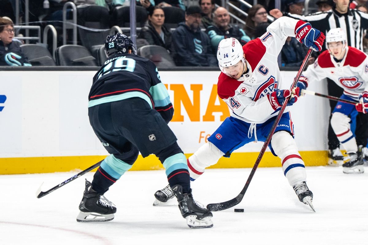 Mar 12, 2025; Seattle, Washington, USA;  Montreal Canadiens forward Nick Suzuki (14) skates against Seattle Kraken defenseman Vince Dunn (29) during the second period at Climate Pledge Arena. Mandatory Credit: Stephen Brashear-Imagn Images