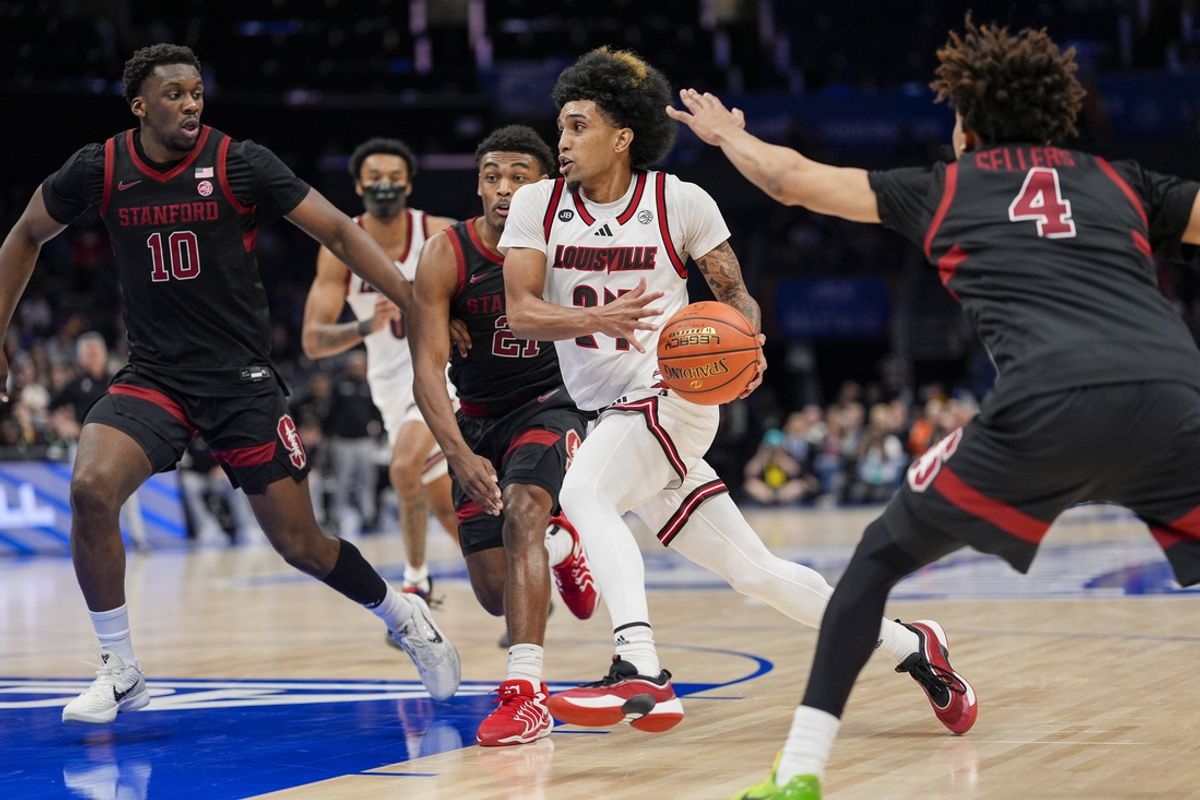 Mar 13, 2025; Charlotte, NC, USA; Louisville Cardinals guard Chucky Hepburn (24) drives to the basket against Stanford Cardinal forward Chisom Okpara (10) during the second half at Spectrum Center. Mandatory Credit: Jim Dedmon-Imagn Images
