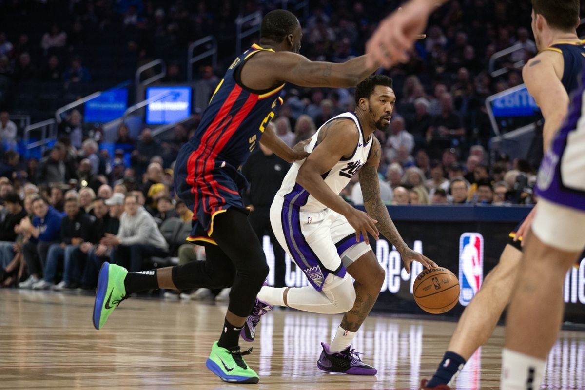 Mar 13, 2025; San Francisco, California, USA; Sacramento Kings guard Malik Monk (0) dribbles past Golden State Warriors forward Draymond Green (23) during the first quarter at Chase Center. Mandatory Credit: D. Ross Cameron-Imagn Images