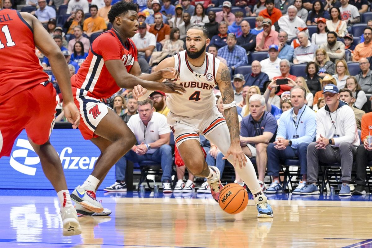 Mar 14, 2025; Nashville, TN, USA;  Auburn Tigers forward Johni Broome (4) dribbles past Mississippi Rebels forward Malik Dia (0) during the first half at Bridgestone Arena. Mandatory Credit: Steve Roberts-Imagn Images