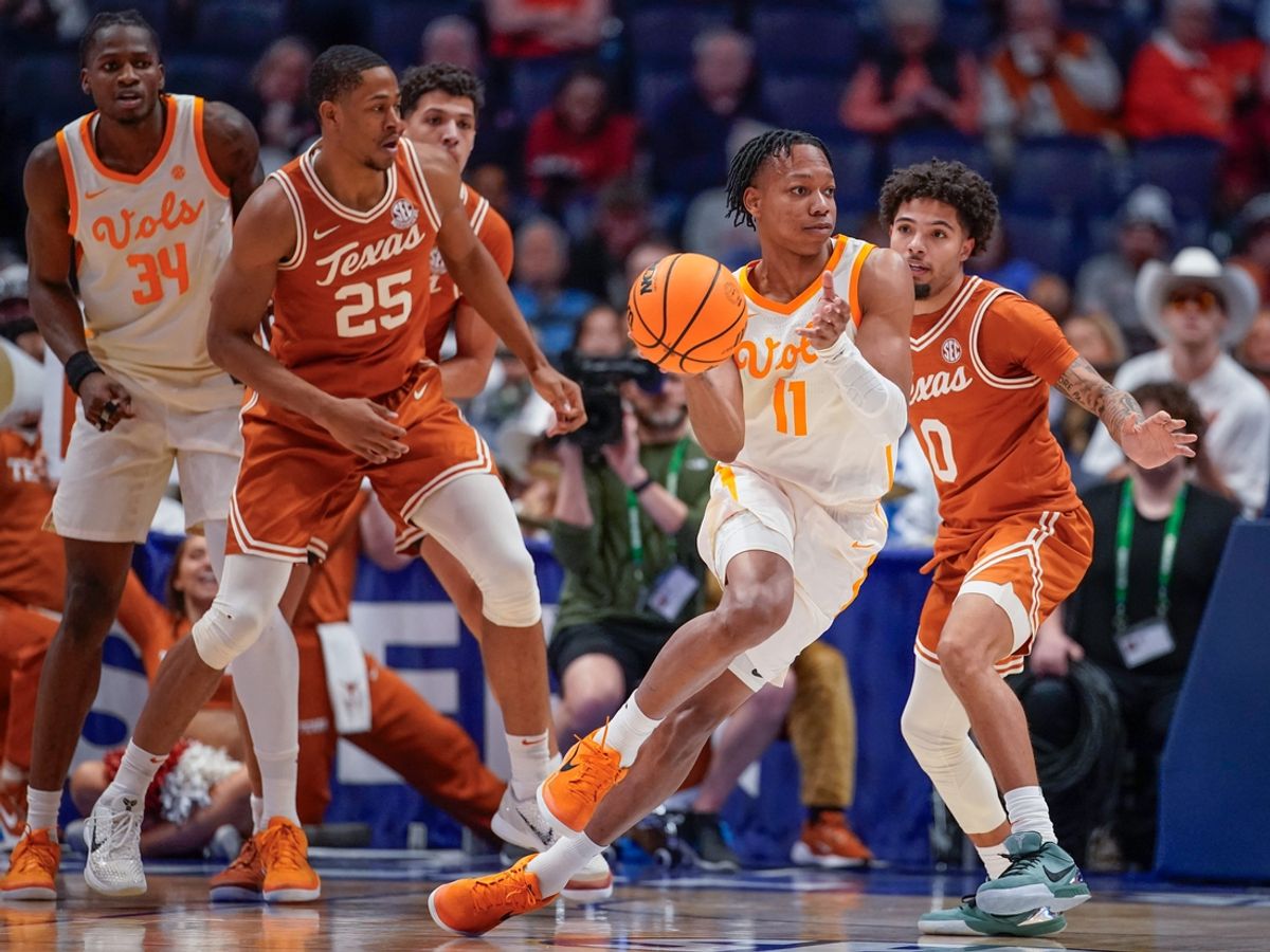 Tennessee guard Jordan Gainey (11) passes around Texas guard Jordan Pope (0) during the first half of a Southeastern Conference tournament quarterfinal game at Bridgestone Arena in Nashville, Tenn., Friday, March 14, 2025.