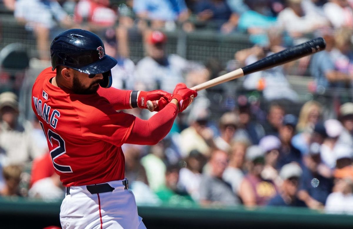 Mar 11, 2025; Fort Myers, Florida, USA;  Boston Red Sox Connor Wong (12) connects with the ball in the first inning of their game with the Philadelphia Phillies at JetBlue Park at Fenway South. Mandatory Credit: Chris Tilley-Imagn Images
