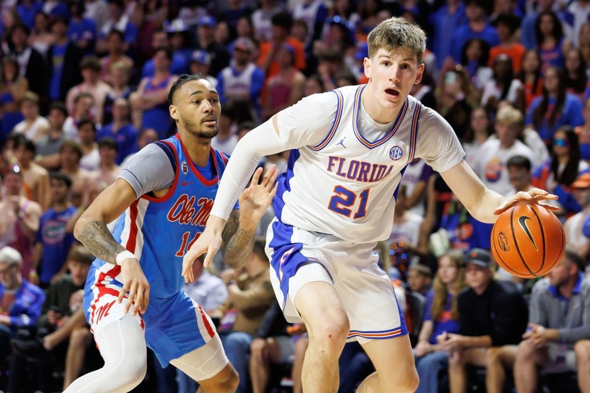 Mar 8, 2025; Gainesville, Florida, USA; Florida Gators forward Alex Condon (21) dribbles the ball while Mississippi Rebels guard Dre Davis (14) defends during the second half at Exactech Arena at the Stephen C. O'Connell Center. Mandatory Credit: Matt Pendleton-Imagn Images