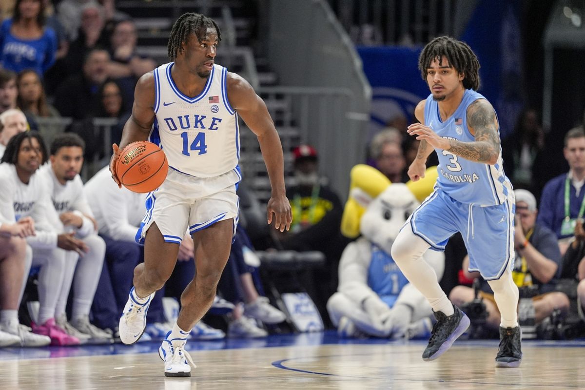 Mar 14, 2025; Charlotte, NC, USA; Duke Blue Devils guard Sion James (14) handles the ball defended by North Carolina Tar Heels guard Elliot Cadeau (3) during the first half at Spectrum Center. Mandatory Credit: Jim Dedmon-Imagn Images