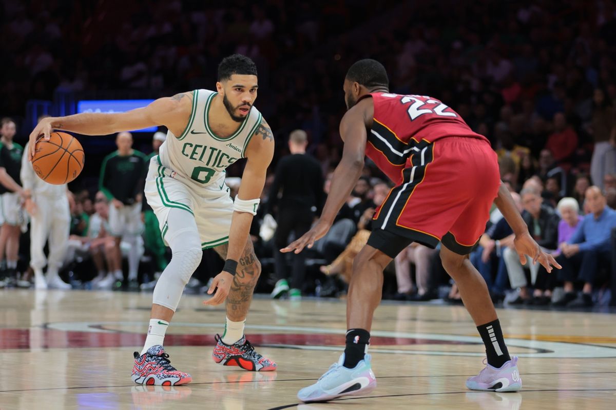 Mar 14, 2025; Miami, Florida, USA; Boston Celtics forward Jayson Tatum (0) dribbles the basketball as Miami Heat forward Andrew Wiggins (22) defends during the fourth quarter at Kaseya Center. Mandatory Credit: Sam Navarro-Imagn Images