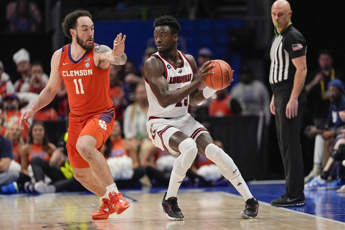 Mar 14, 2025; Charlotte, NC, USA; Louisville Cardinals forward Aboubacar Traore (25) handles the ball against Clemson Tigers guard Jaeden Zackery (11) during the first half at Spectrum Center. Mandatory Credit: Jim Dedmon-Imagn Images