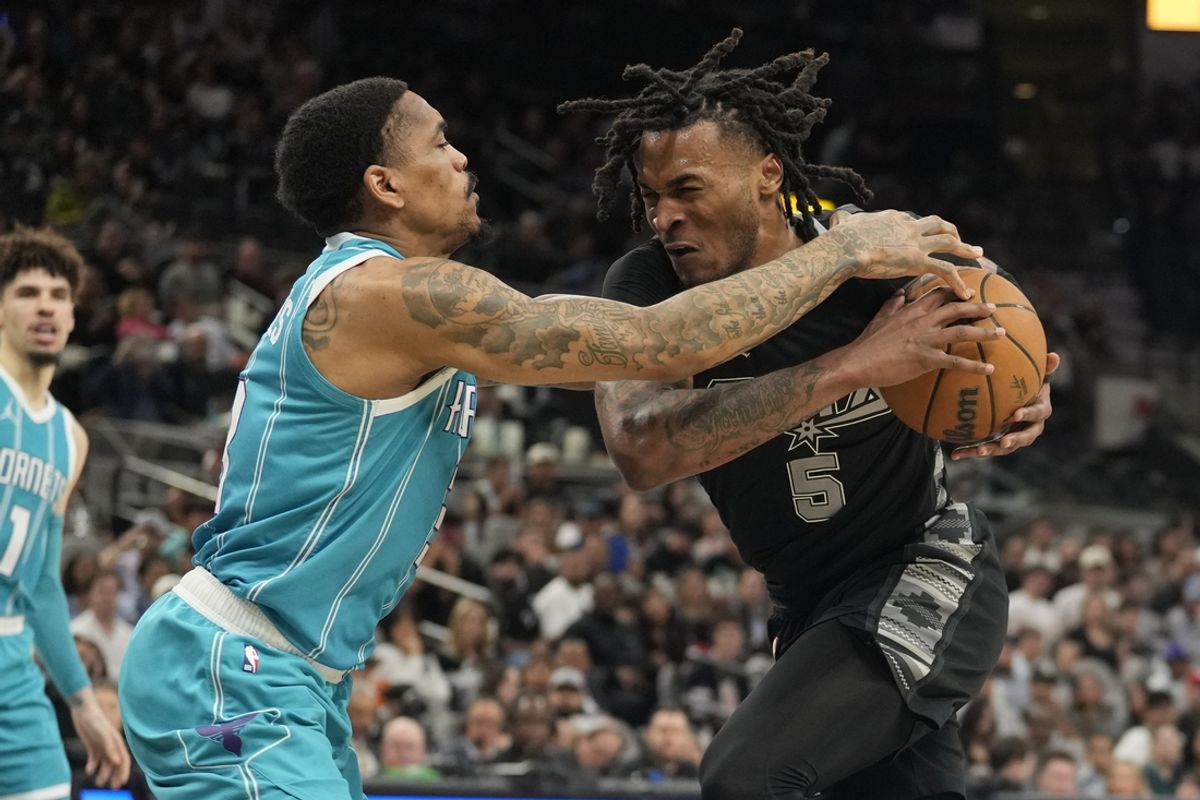 Mar 14, 2025; San Antonio, Texas, USA; San Antonio Spurs guard Stephon Castle (5) drives to the basket while defended by Charlotte Hornets DaQuan Jeffries (3) during the second half at Frost Bank Center. Mandatory Credit: Scott Wachter-Imagn Images