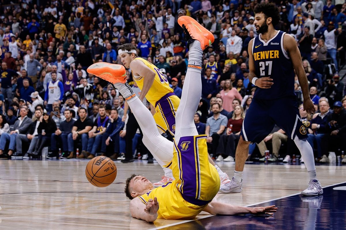 Mar 14, 2025; Denver, Colorado, USA; Los Angeles Lakers guard Dalton Knecht (4) falls to the court after a dunk in the fourth quarter against the Denver Nuggets at Ball Arena. Mandatory Credit: Isaiah J. Downing-Imagn Images