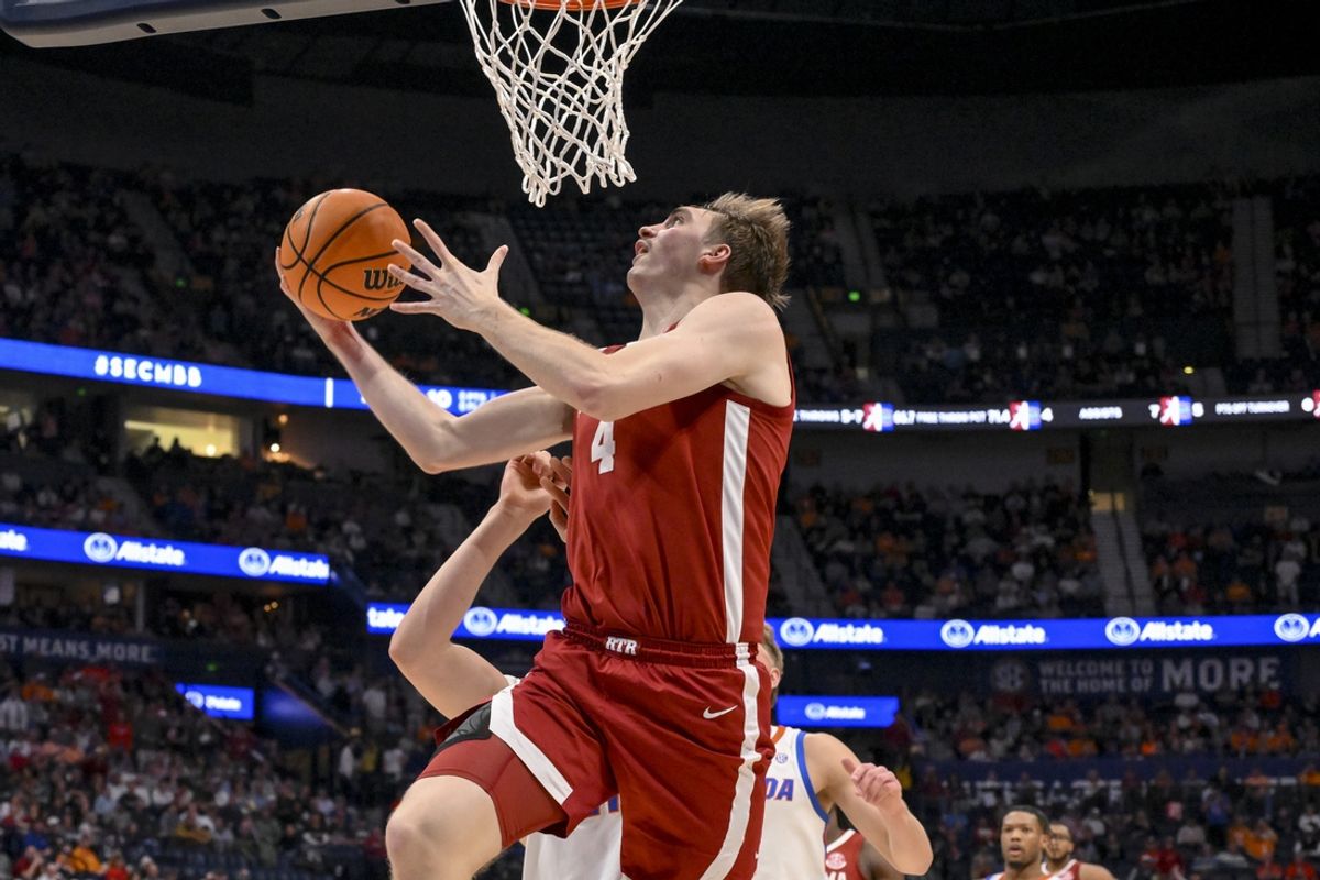 Mar 15, 2025; Nashville, TN, USA;  Alabama Crimson Tide forward Grant Nelson (4) lays the ball in over  Florida Gators forward Alex Condon (21) during the first half at Bridgestone Arena. Mandatory Credit: Steve Roberts-Imagn Images