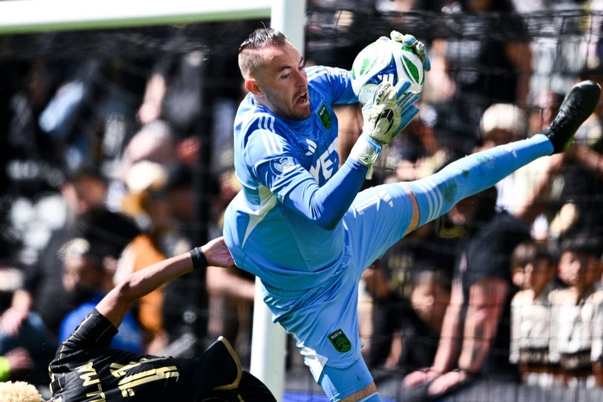 Mar 15, 2025; Los Angeles, California, USA; Austin FC goalkeeper Brad Stuver (1) grabs onto the ball while Los Angeles FC midfielder Timothy Tillman (11) falls to the field during the second half at BMO Stadium. Mandatory Credit: Kelvin Kuo-Imagn Images