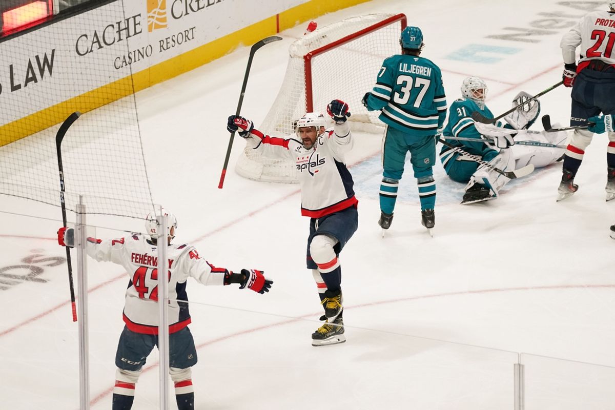 Mar 15, 2025; San Jose, California, USA;  Washington Capitals left wing Alex Ovechkin (8) scores career goal 887 past San Jose Sharks goaltender Georgi Romanov (31) and celebrates with Washington Capitals defenseman Martin Fehervary (42) in the third period at SAP Center at San Jose. Mandatory Credit: David Gonzales-Imagn Images