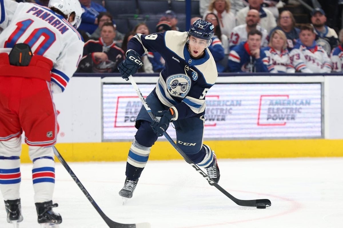 Mar 15, 2025; Columbus, Ohio, USA;  Columbus Blue Jackets right wing Yegor Chinakhov (59) shoots the puck as New York Rangers left wing Artemi Panarin (10) defends during the second period at Nationwide Arena. Mandatory Credit: Joseph Maiorana-Imagn Images