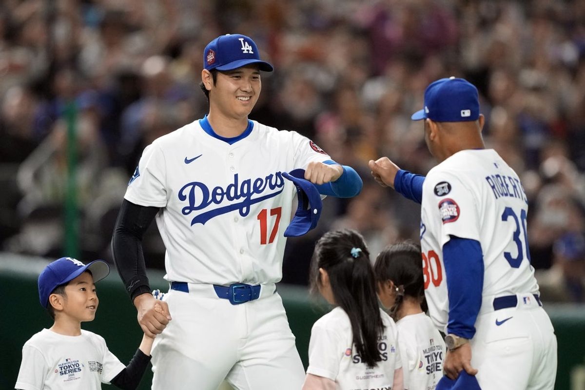 Mar 16, 2025; Bunkyo, Tokyo, Japan; Los Angeles Dodgers designated hitter Shohei Ohtani (17) greets manager Dave Roberts (30) during player introductions before the game against the Hanshin Tigers at Tokyo Dome. Mandatory Credit: Darren Yamashita-Imagn Images
