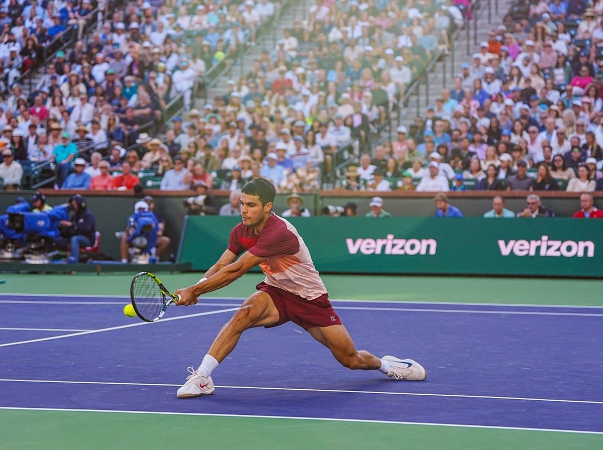 Carlos Alcaraz slides across the court for a backhanded shot to Jack Draper during the ATP semifinals at the BNP Paribas Open in Indian Wells, Calif., Saturday, March 15, 2025.