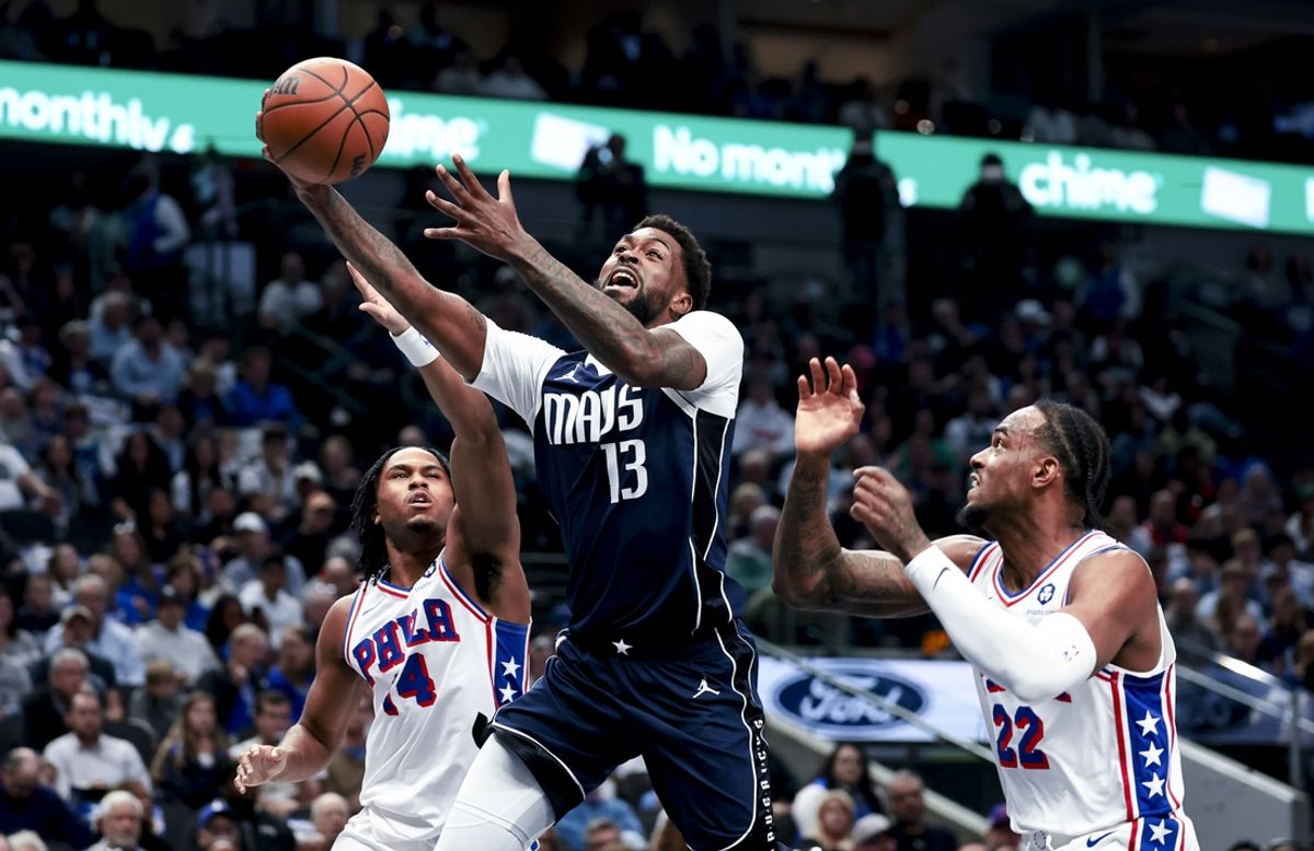 Mar 16, 2025; Dallas, Texas, USA;  Dallas Mavericks forward Naji Marshall (13) shoot spast Philadelphia 76ers forward Oshae Brissett (22) and Philadelphia 76ers guard Ricky Council IV (14) during the first half at American Airlines Center. Mandatory Credit: Kevin Jairaj-Imagn Images