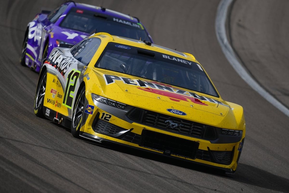 Mar 16, 2025; Las Vegas, Nevada, USA; NASCAR series driver Joey Logano (22) leads driver Denny Hamlin (11) during the Pennzoil 400 at Las Vegas Motor Speedway. Mandatory Credit: Gary A. Vasquez-Imagn Images