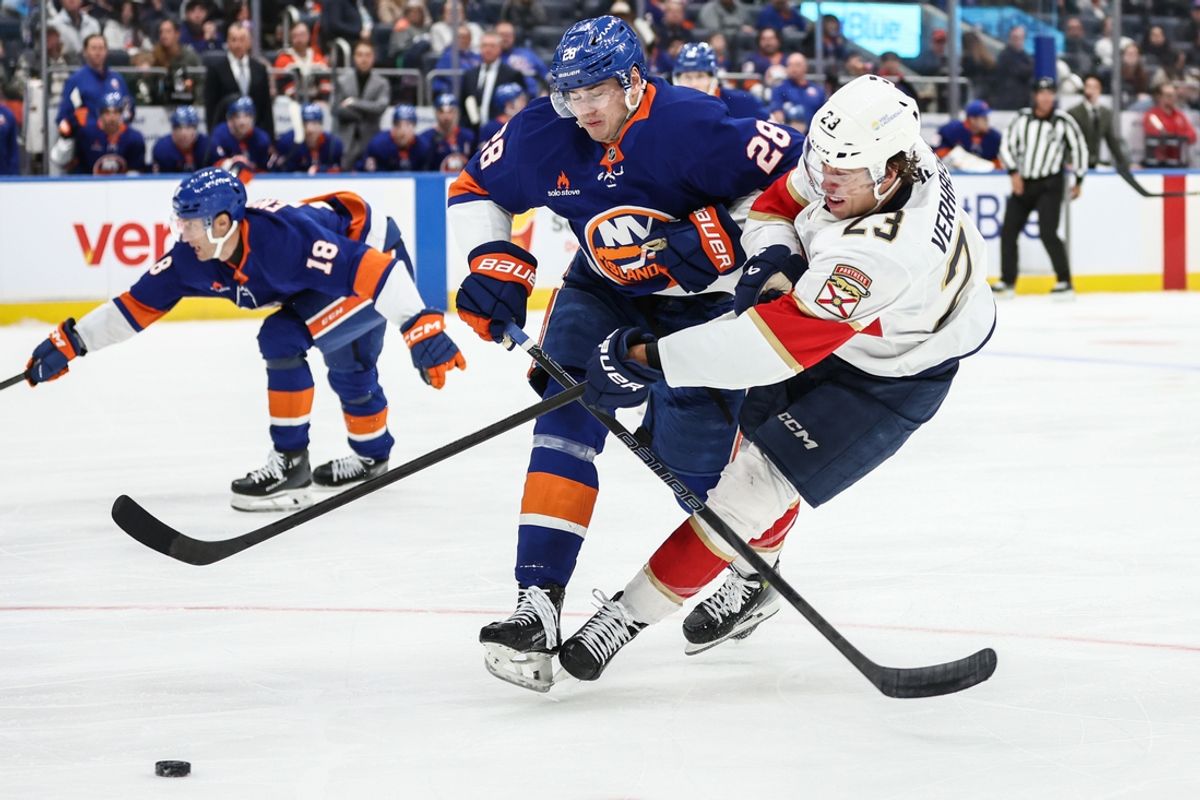 Mar 16, 2025; Elmont, New York, USA;  New York Islanders defenseman Alexander Romanov (28) collides with Florida Panthers center Carter Verhaeghe (23) in the first period at UBS Arena. Mandatory Credit: Wendell Cruz-Imagn Images