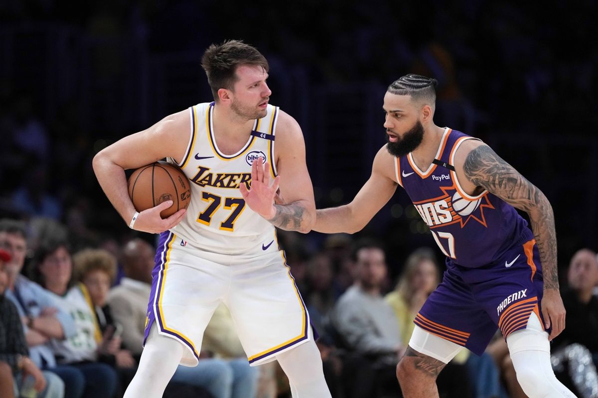Mar 16, 2025; Los Angeles, California, USA; Los Angeles Lakers guard Luka Doncic (77) is defended by Phoenix Suns forward Cody Martin (17)  in the second half at Crypto.com Arena. Mandatory Credit: Kirby Lee-Imagn Images