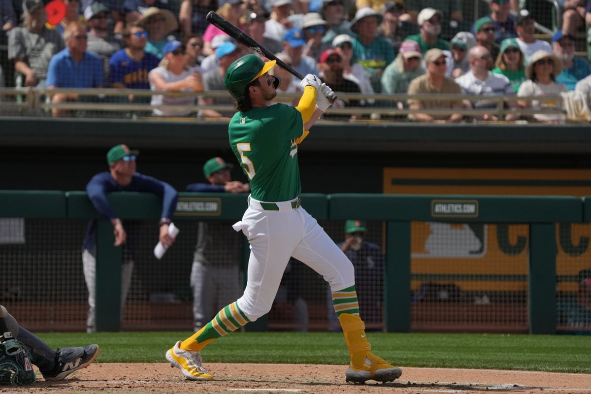 Mar 17, 2025; Mesa, Arizona, USA; Oakland Athletics shortstop Jacob Wilson (5) hits a solo home run against the Seattle Mariners in the third inning at Hohokam Stadium. Mandatory Credit: Rick Scuteri-Imagn Images