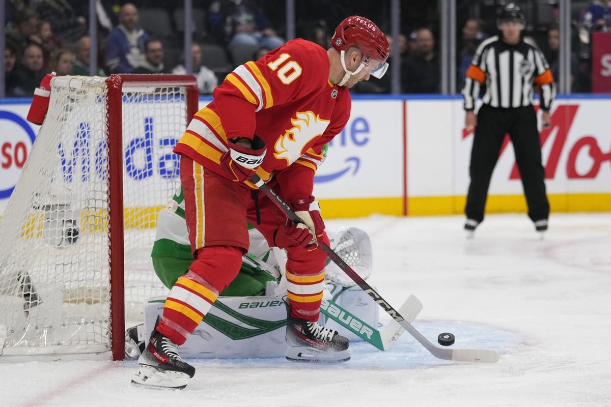 Mar 17, 2025; Toronto, Ontario, CAN; Calgary Flames forward Jonathan Huberdeau (10) deflects a shot at the Toronto Maple Leafs net during the second period at Scotiabank Arena. Mandatory Credit: John E. Sokolowski-Imagn Images