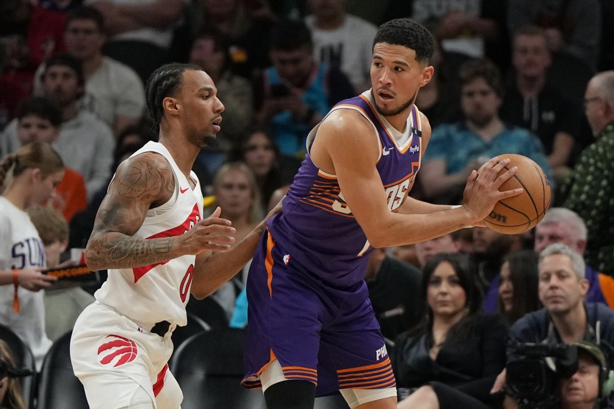 Mar 17, 2025; Phoenix, Arizona, USA; Phoenix Suns guard Devin Booker (1) shields the ball from Toronto Raptors guard A.J. Lawson (0) in the first half at Footprint Center. Mandatory Credit: Rick Scuteri-Imagn Images