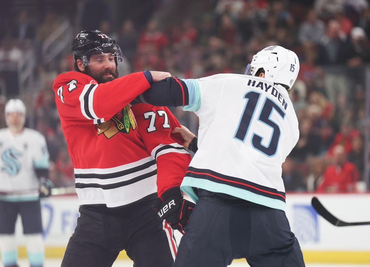 Mar 18, 2025; Chicago, Illinois, USA; Chicago Blackhawks left wing Patrick Maroon (77) and Seattle Kraken center John Hayden (15) fight during the first period at United Center. Mandatory Credit: Talia Sprague-Imagn Images