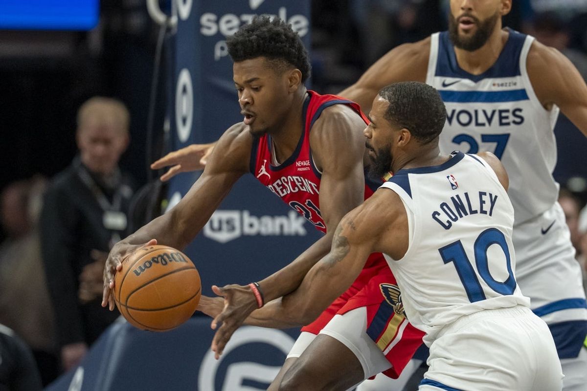 Mar 19, 2025; Minneapolis, Minnesota, USA; New Orleans Pelicans center Yves Missi (21) attempts to protect the ball from Minnesota Timberwolves guard Mike Conley (10) in the first half at Target Center. Mandatory Credit: Jesse Johnson-Imagn Images