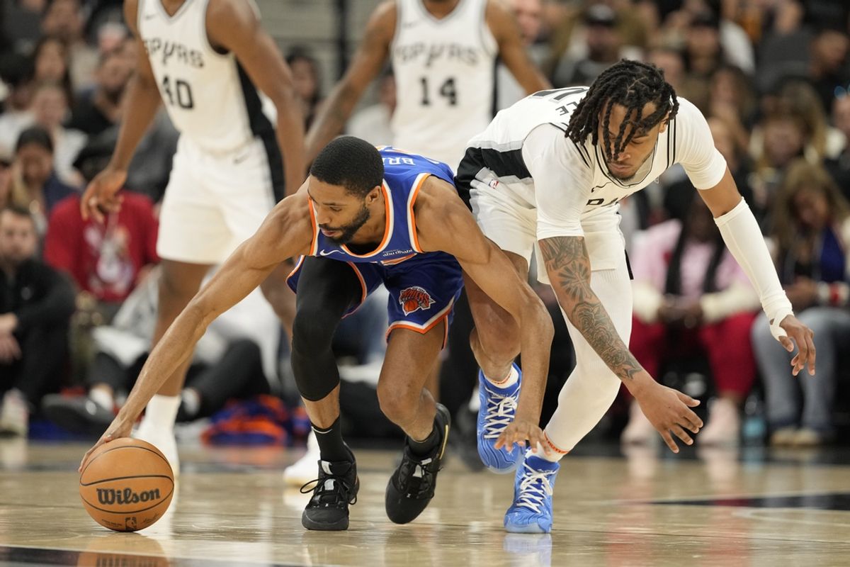 Mar 19, 2025; San Antonio, Texas, USA; New York Knicks forward Mikal Bridges (25) and San Antonio Spurs guard Stephon Castle (5) battle for a loose ball during the first half at Frost Bank Center. Mandatory Credit: Scott Wachter-Imagn Images