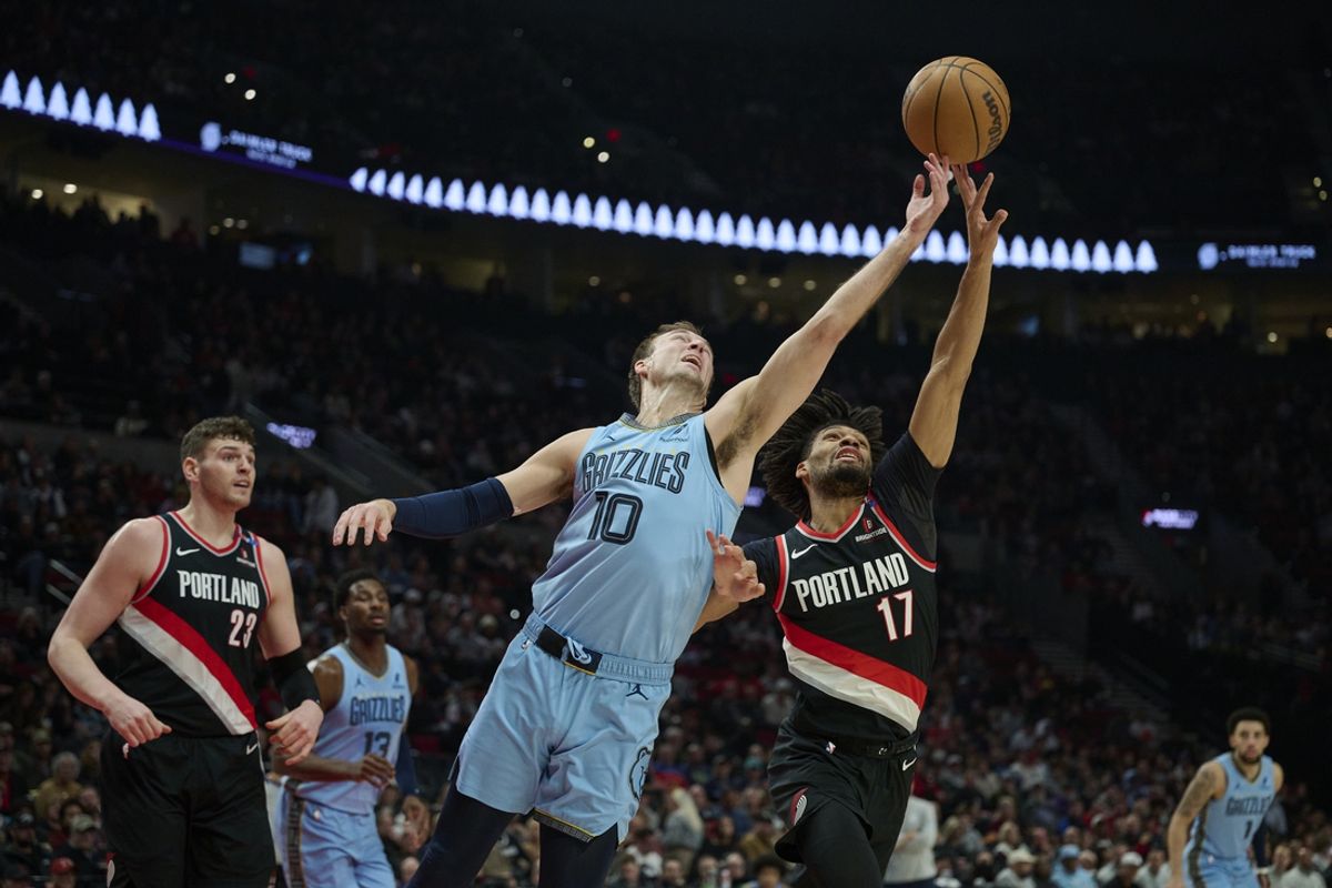 Mar 19, 2025; Portland, Oregon, USA; Memphis Grizzlies guard Luke Kennard (10) reaches for a rebound during the first half against Portland Trail Blazers guard Shaedon Sharpe (17) at Moda Center. Mandatory Credit: Troy Wayrynen-Imagn Images