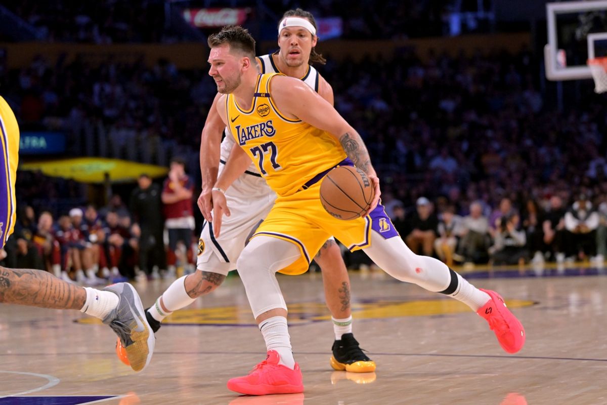 Mar 19, 2025; Los Angeles, California, USA;  Los Angeles Lakers guard Luka Doncic (77) drives past Denver Nuggets forward Aaron Gordon (32) in the first half at Crypto.com Arena. Mandatory Credit: Jayne Kamin-Oncea-Imagn Images