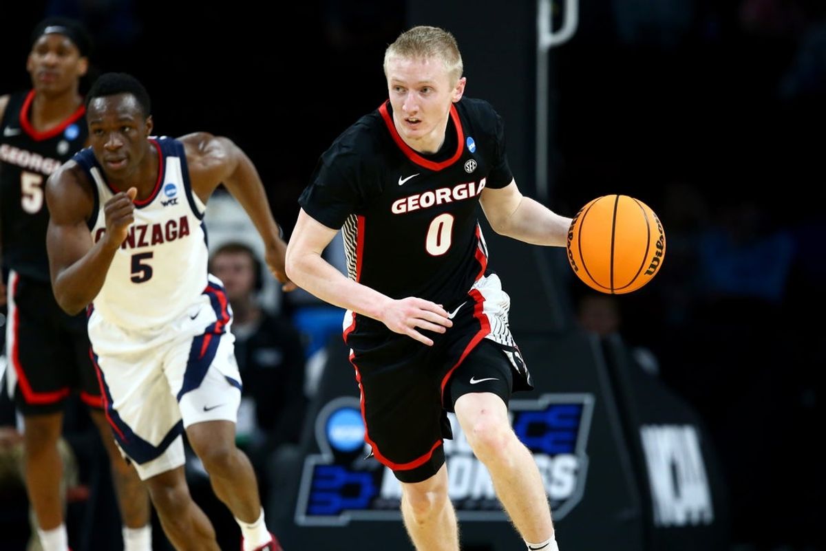 Mar 20, 2025; Wichita, KS, USA; Georgia Bulldogs guard Blue Cain (0) dribbles from Gonzaga Bulldogs forward Emmanuel Innocenti (5) in the second half of a first round men’s NCAA Tournament game at Intrust Bank Arena. Mandatory Credit: Nick Tre. Smith-Imagn Images