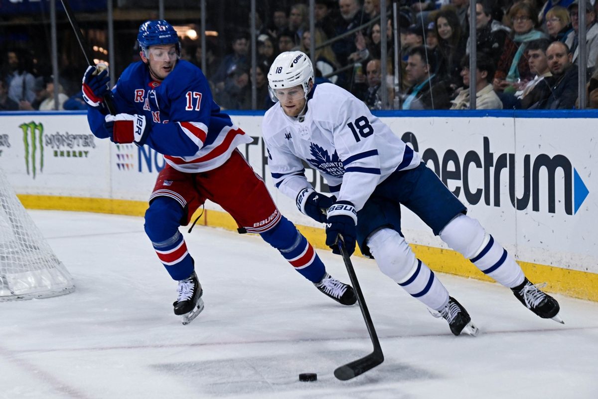 Mar 20, 2025; New York, New York, USA;  Toronto Maple Leafs center Steven Lorentz (18) skates the puck from behind the net chased by New York Rangers defenseman Will Borgen (17) during the first period at Madison Square Garden. Mandatory Credit: Dennis Schneidler-Imagn Images