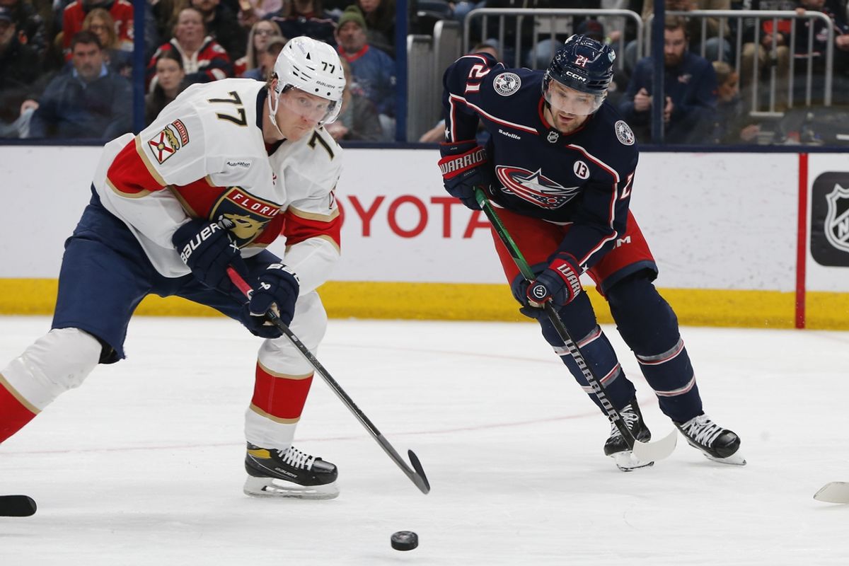 Mar 20, 2025; Columbus, Ohio, USA; Florida Panthers defenseman Niko Mikkola (77) clears a loose puck as Columbus Blue Jackets left wing James van Riemsdyk (21) look for the rebound during the second period at Nationwide Arena. Mandatory Credit: Russell LaBounty-Imagn Images