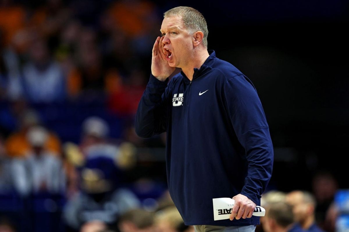 Mar 20, 2025; Lexington, KY, USA;  Utah State Aggies head coach Jerrod Calhoun calls to his team during the first half against the UCLA Bruins in the first round of the NCAA Tournament at Rupp Arena. Mandatory Credit: Aaron Doster-Imagn Images