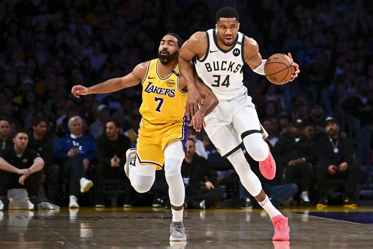 Mar 20, 2025; Los Angeles, California, USA; Milwaukee Bucks forward Giannis Antetokounmpo (34) moves the ball against Los Angeles Lakers guard Gabe Vincent (7) during the first half at Crypto.com Arena. Mandatory Credit: Jonathan Hui-Imagn Images