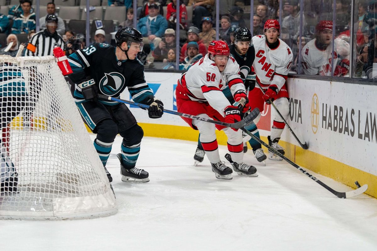Mar 20, 2025; San Jose, California, USA; h50 and San Jose Sharks defenseman Jimmy Schuldt (59) battle for the puck behind the net during the first period at SAP Center at San Jose. Mandatory Credit: Neville E. Guard-Imagn Images