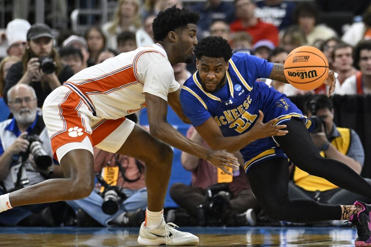 Mar 20, 2025; Providence, RI, USA; McNeese State Cowboys guard Sincere Parker (21) drives against Clemson Tigers forward Chauncey Wiggins (7) during the first half at Amica Mutual Pavilion. Mandatory Credit: Eric Canha-Imagn Images