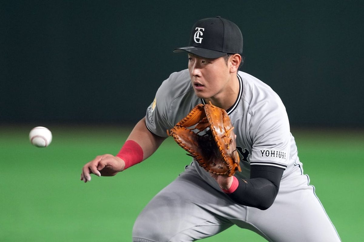 Mar 15, 2025; Bunkyo, Tokyo, Japan; Yomiuri Giants first baseman Kazuma Okamoto (25) fields a ground ball against the Los Angeles Dodgers during the fifth inning at Tokyo Dome. Mandatory Credit: Darren Yamashita-Imagn Images