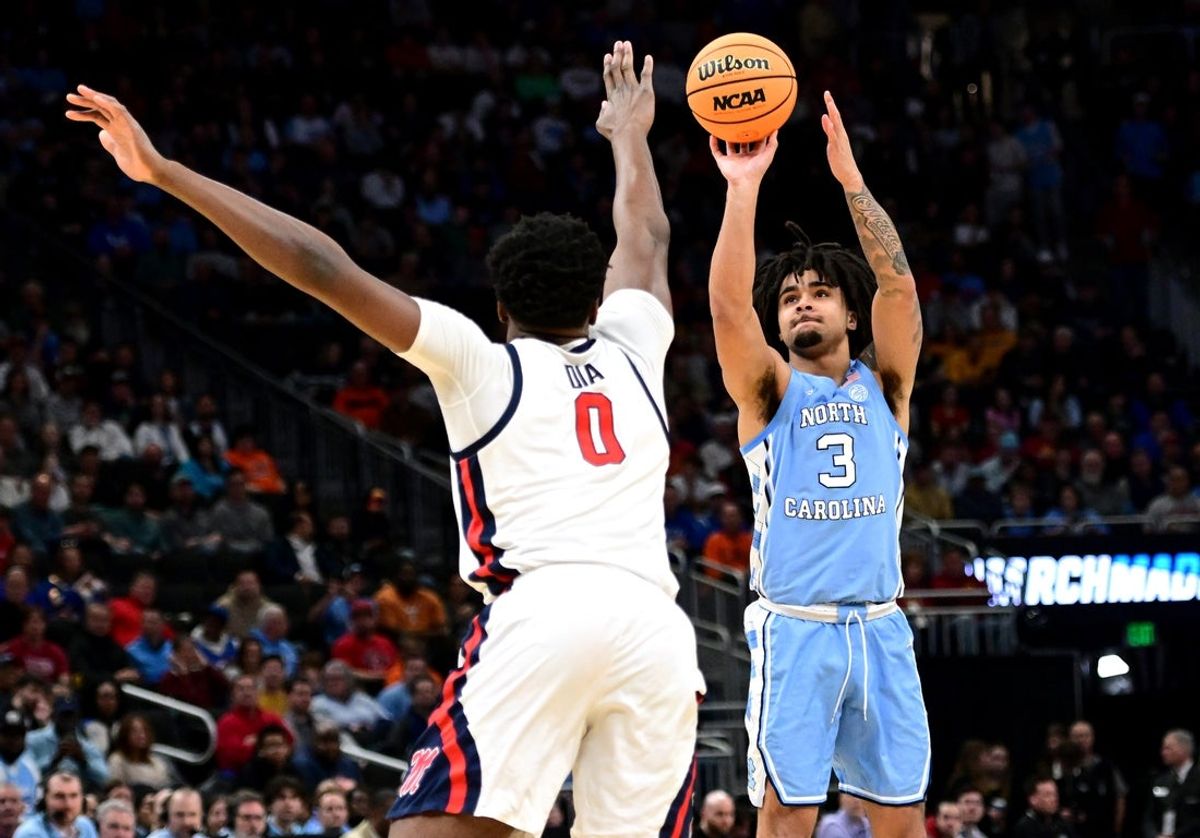 Mar 21, 2025; Milwaukee, WI, USA; North Carolina Tar Heels guard Elliot Cadeau (3) shoots against Mississippi Rebels forward Malik Dia (0) during the first half of a first round NCAA men’s tournament game at Fiserv Forum. Mandatory Credit: Benny Sieu-Imagn Images