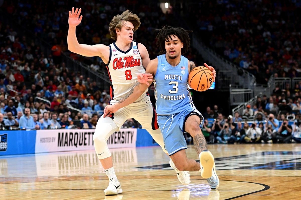 Mar 21, 2025; Milwaukee, WI, USA; North Carolina Tar Heels guard Elliot Cadeau (3) drives against Mississippi Rebels guard Eduardo Klafke (8) during the first half of a first round NCAA men’s tournament game at Fiserv Forum. Mandatory Credit: Benny Sieu-Imagn Images