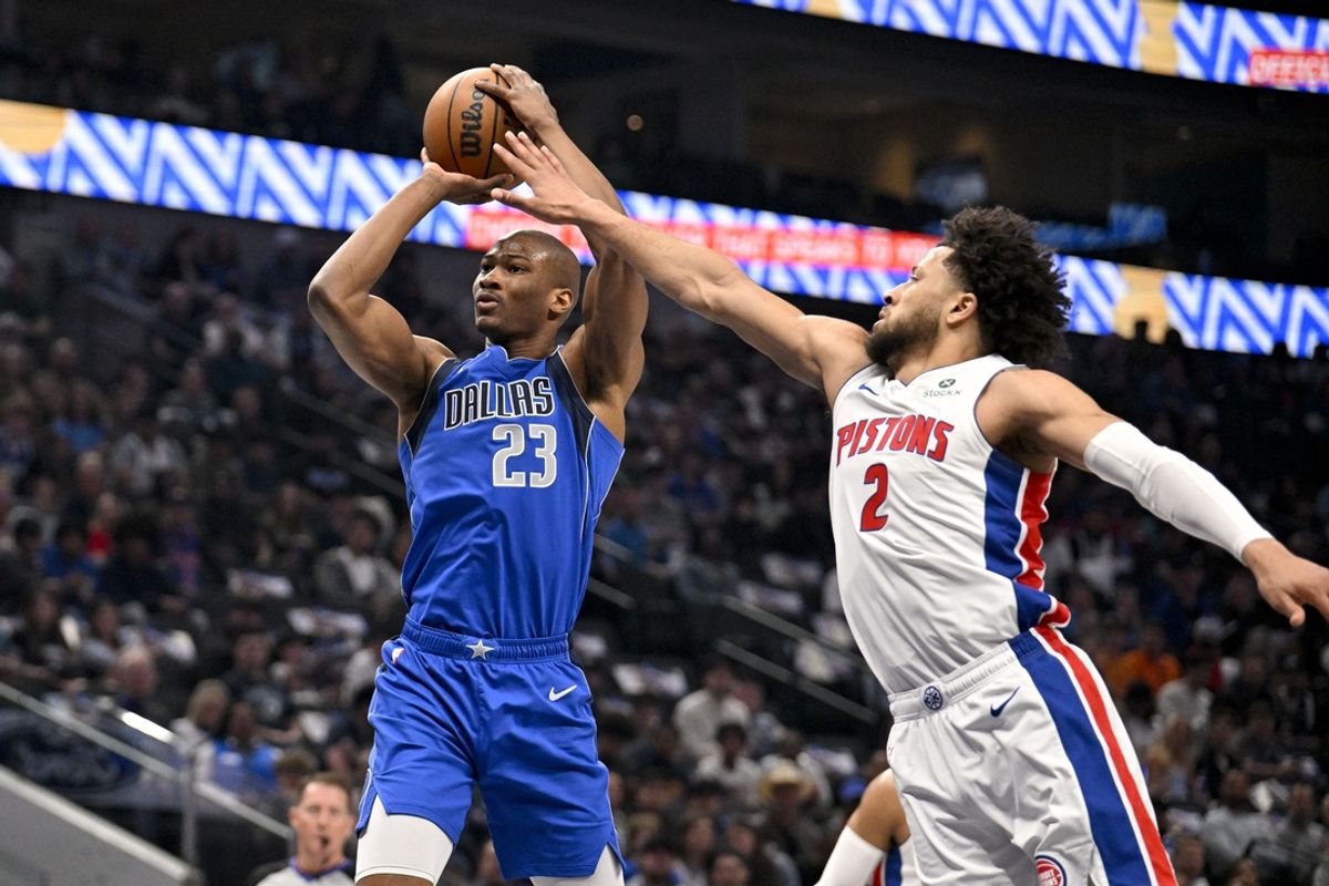 Mar 21, 2025; Dallas, Texas, USA; Dallas Mavericks forward Kai Jones (23) shoots the ball past Detroit Pistons guard Cade Cunningham (2) during the first quarter at the American Airlines Center. Mandatory Credit: Jerome Miron-Imagn Images