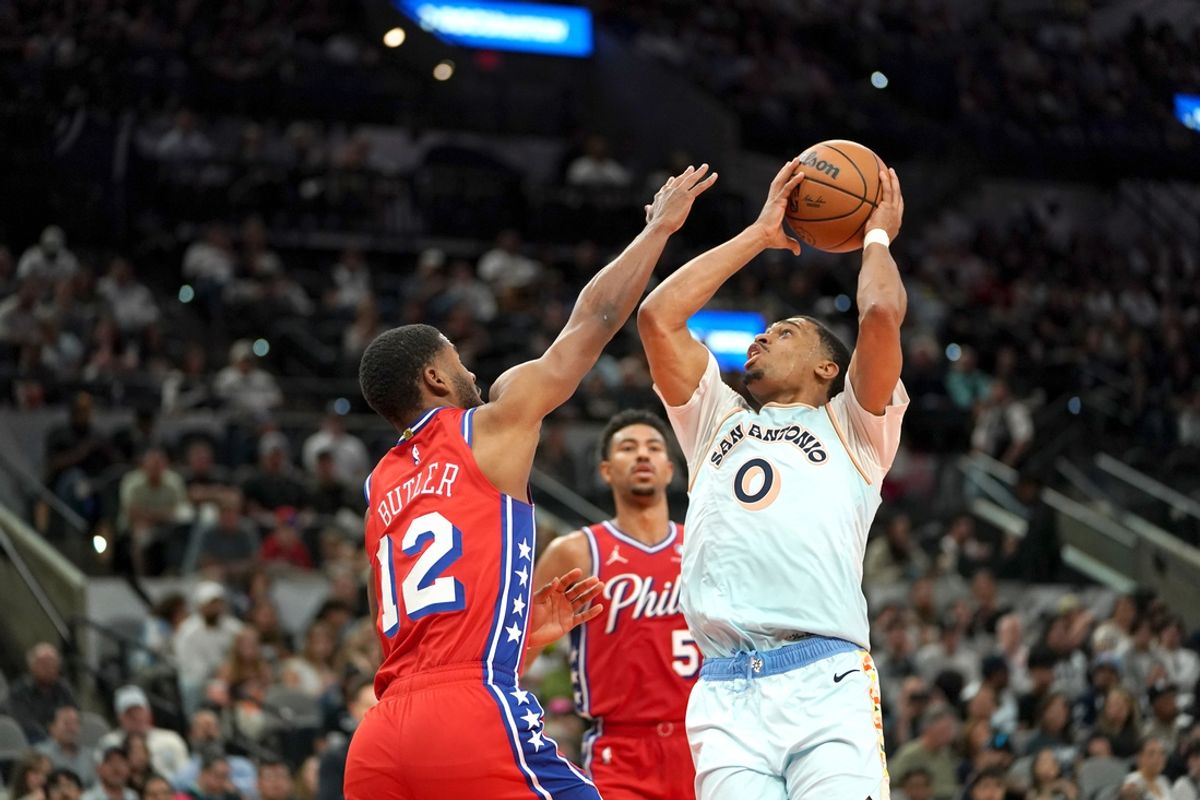 Mar 21, 2025; San Antonio, Texas, USA; San Antonio Spurs forward Keldon Johnson (0) shoots the ball against Philadelphia 76ers guard Jared Butler (12) during the second quarter at Frost Bank Center. Mandatory Credit: Dustin Safranek-Imagn Images