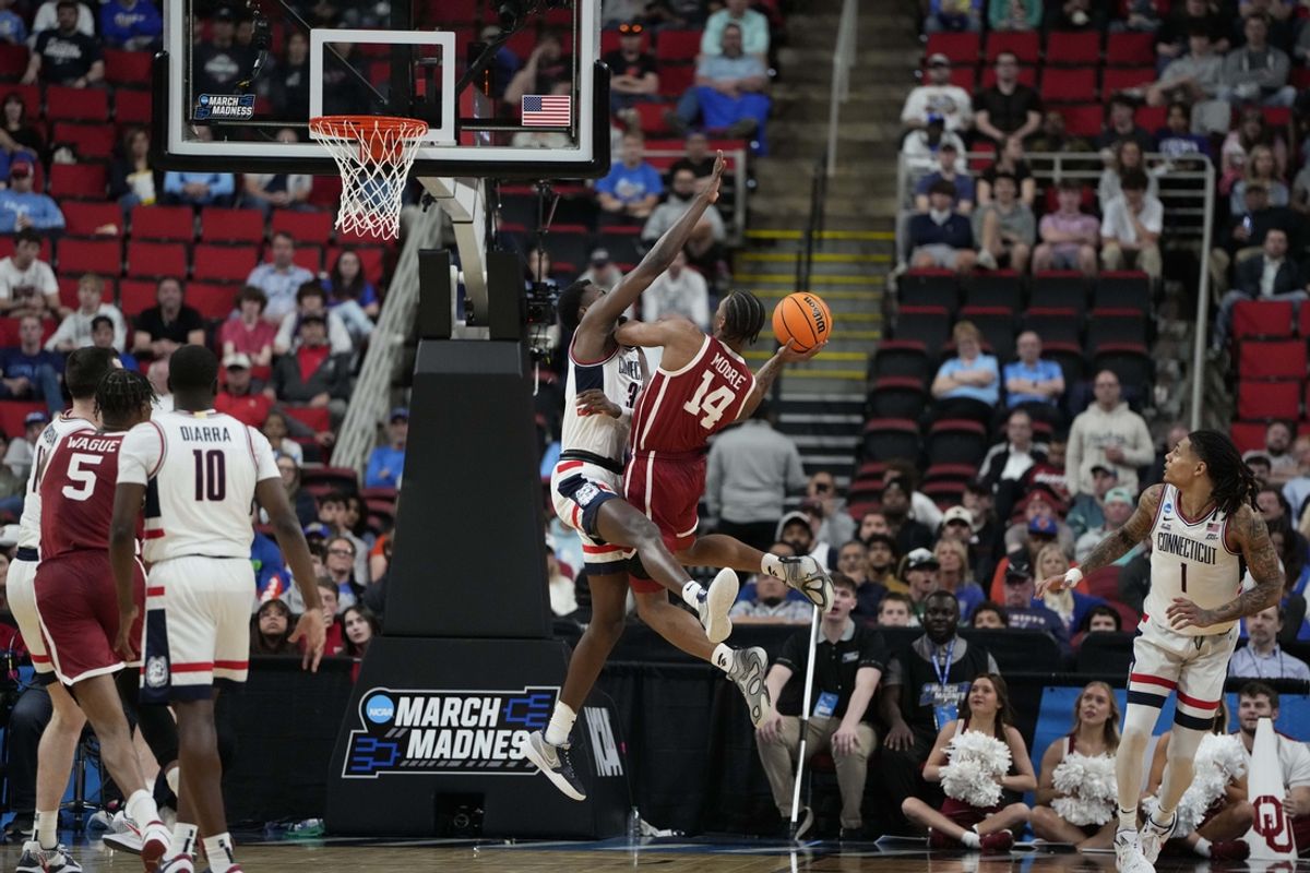 Mar 21, 2025; Raleigh, NC, USA;  Connecticut Huskies forward Jaylin Stewart (3) defends against Oklahoma Sooners forward Jalon Moore (14) during the second half at Lenovo Center. Mandatory Credit: Bob Donnan-Imagn Images