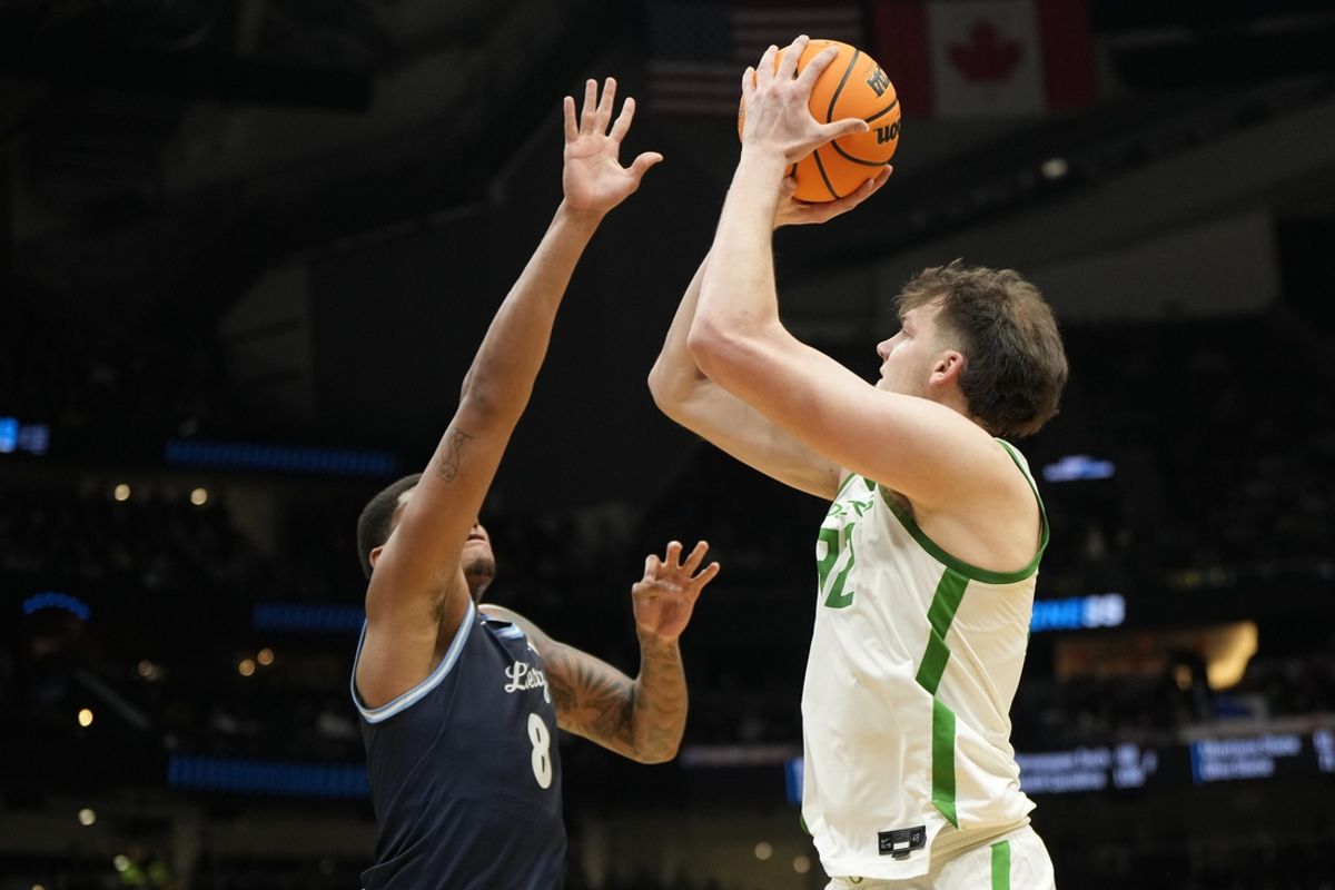Mar 21, 2025; Seattle, WA, USA; Oregon Ducks center Nate Bittle (32) shoots the ball over Liberty Flames forward Owen Aquino (8) during the first half in the first round of the NCAA Tournament  at Climate Pledge Arena. Mandatory Credit: Stephen Brashear-Imagn Images