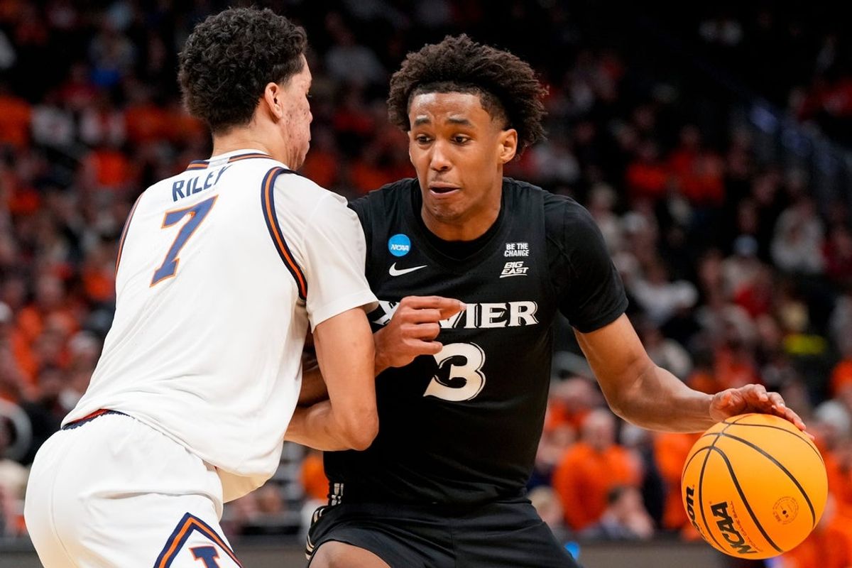 Xavier Musketeers guard Dailyn Swain (3) drives against Illinois Fighting Illini forward Will Riley (7) in the second half of the NCAA Tournament First Round game between the Illinois Fighting Illini and the Xavier Musketeers at Fiserv Forum in Milwaukee on Friday, March 21, 2025. Xavier was eliminated from the tournament, losing 86-73, to Illinois.