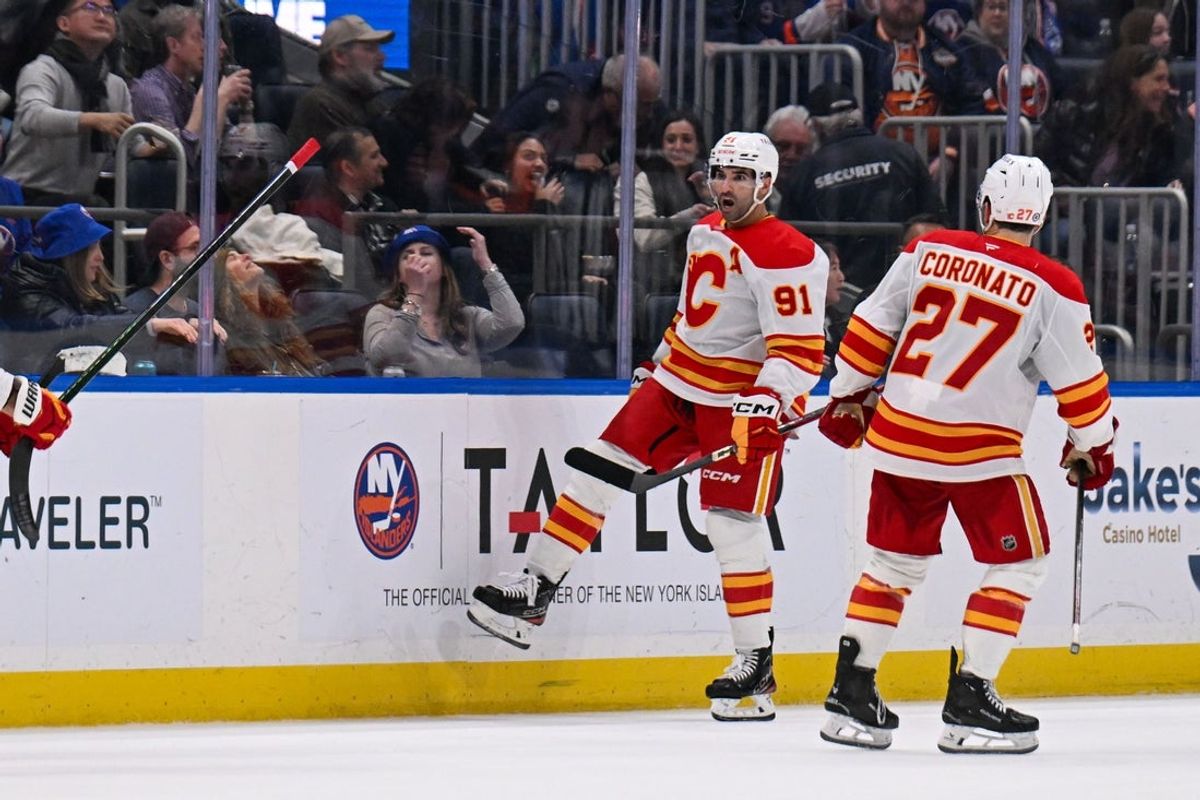 Mar 22, 2025; Elmont, New York, USA;  Calgary Flames center Nazem Kadri (91) Celebrates his game winning goal against the New York Islanders during the overtime period at UBS Arena. Mandatory Credit: Dennis Schneidler-Imagn Images